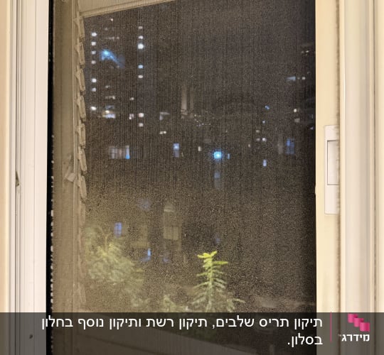 תריסים וחלון עם נוף לילי ברקע